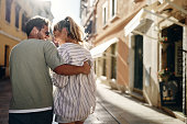 Back view of happy couple enjoying in walk and talk on the street.