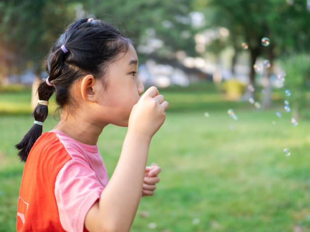 istock Little Girl Blowing Bubbles 1428273367
