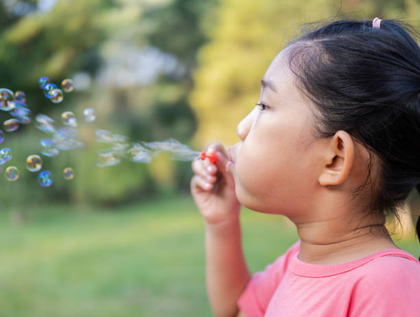istock Little Girl Blowing Bubbles 1428274172