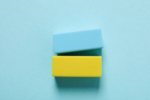 istock Blue and yellow erasers on blue background 1428276022