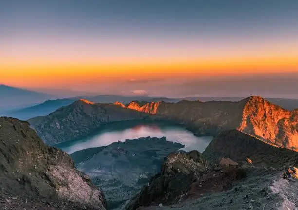 The golden sunlights shine on Mount Rinjani, where you can see the sea, crater lake and Gunung Agung in Bali , this is the most magnificent scenery I have ever seen