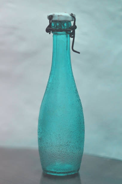istock Empty vintage green glass bottle with ceramic lid and wire stopper on table 1428278396