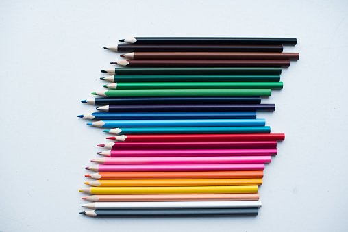 School supplies, a group of colored pencils on the background of a sheet of checkered paper