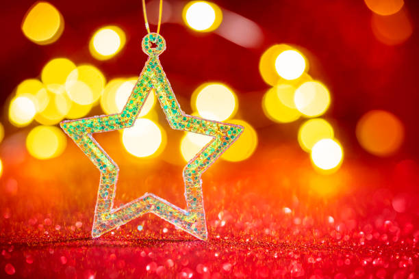 Christmas background star glitter with blurred Christmas lights on red glitter background bokeh