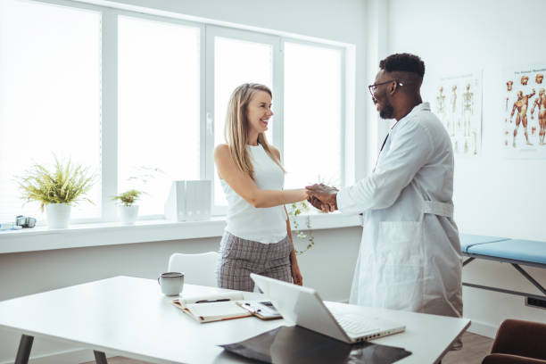 istock Doctor shaking hands with woman. 1428280237