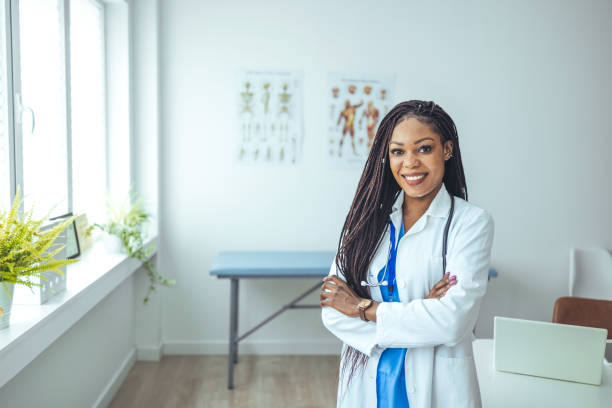 istock Female Doctor In White Coat Posing With Folded Arms Over Light Background. 1428280605