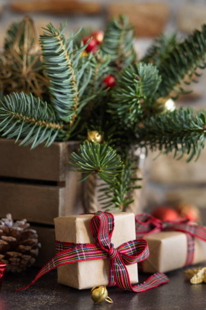 istock Wrapped gift boxes between Christmas decorations, pine cones and green fir branches 1428280930