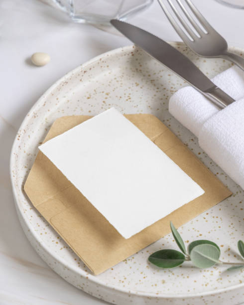 istock Elegant Table setting with a card decorated with eucalyptus branches close up, Wedding mockup 1428281047