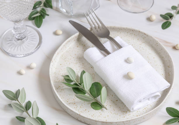 istock Elegant wedding Table setting decorated with eucalyptus branches and white pebbles close up 1428281068
