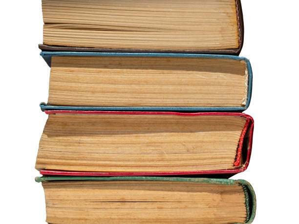 A stack of old yellowed hardcover books isolated on a white background