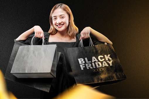 Asian woman carrying a shopping bag with a colored background. Black Friday concept