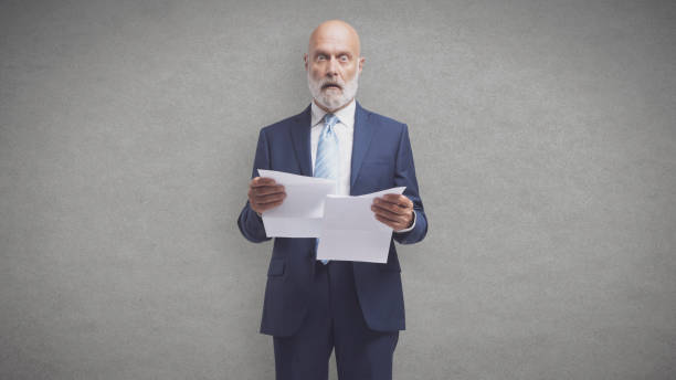 istock Shocked man holding expensive utility bills and invoices 1428282044