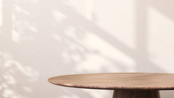 modern round wooden side table with sunlight from window and tropical leaf shadow on white wall background - side table imagens e fotografias de stock