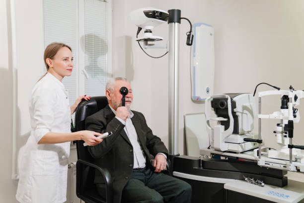 ophthalmologist diagnoses elderly man's vision on a sign projector.
