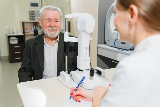istock doctor interviews elderly man before being examined in ophthalmologist's office. 1428287364
