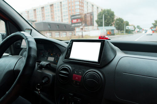View from inside a car on a part of the dashboard with a navigation system. Mockup. Copyspace. Front. Indoors. Mirror. Multimedia. Music. Panel. Race. Travel. Motion. Map. Radio. Volume. System. Trip