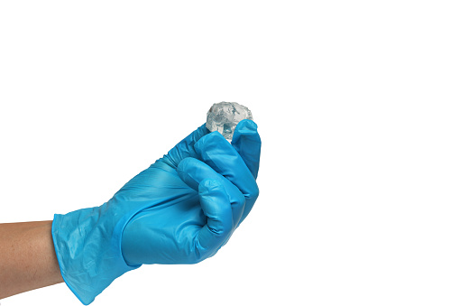 Man's hand wearing nitrile gloves on white background