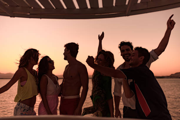 istock Carefree friends having fun while dancing on a boat at sunset. 1428290028