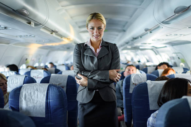 istock Happy female flight attendant among seats in a plane. 1428290447
