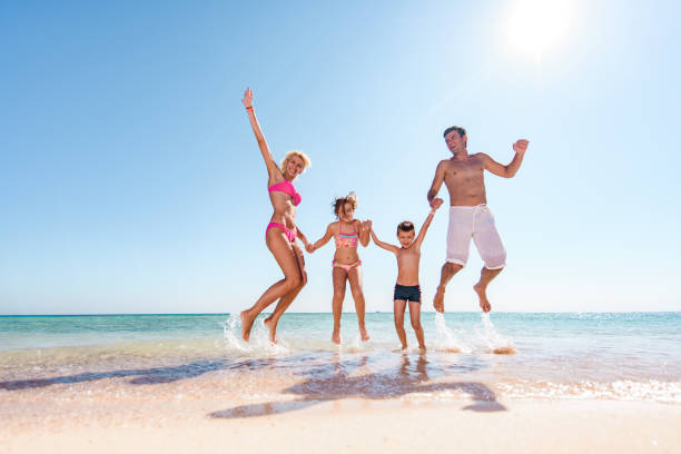 istock Playful family having fun while jumping on the beach. 1428290560