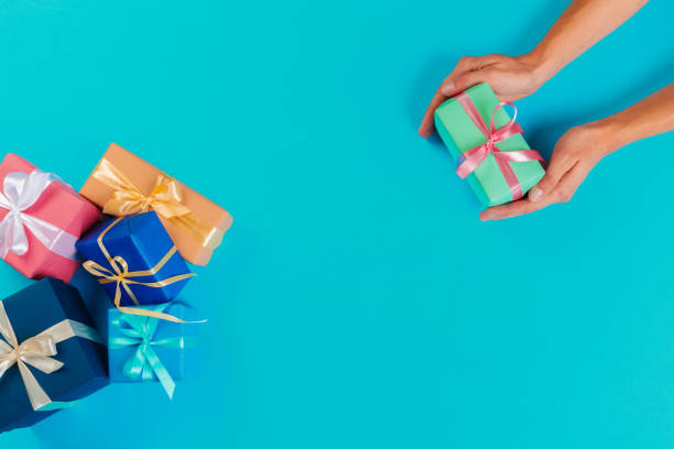 istock Woman holding gift box on color background 1428295581