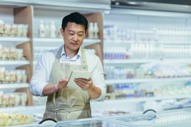 istock Internship at work. A young man, an Asian stager,student, an assistant works in a supermarket 1428296953