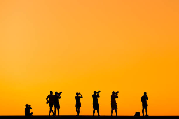 Silhouette of some photographer people on sunset.