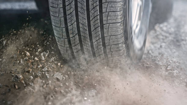 istock Dust splashing from tire of car driving 1428298675