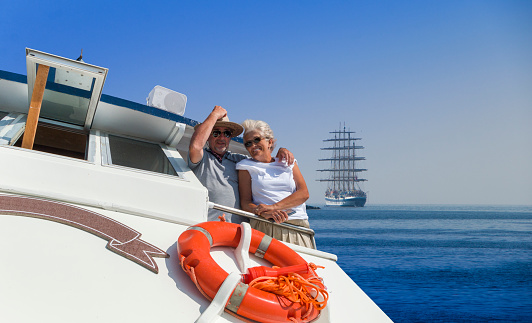 Senior couple enjoy sailing on a boat.  Sunny day. Clear blue sky on background.