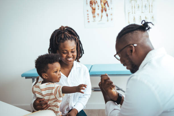 pediatra africano do sexo masculino realiza exame de estetoscópio menino criança - 18 a 23 meses - fotografias e filmes do acervo