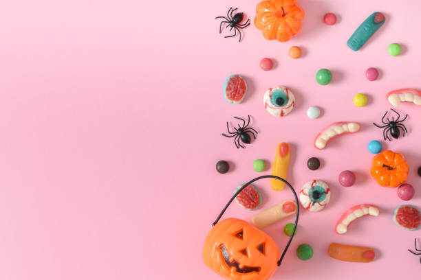 istock Banner with various sweets on a pink background. Happy Halloween. Space for copying. Flat position, top view 1428304549