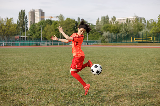 Girl kicking a soccer ball with her heel