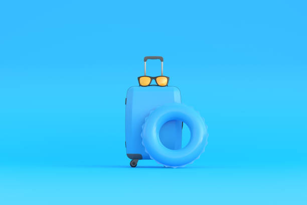 istock Suitcase, glasses and inflatable circle on a blue background with copy space 1428315388