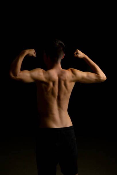 istock Nineteen year old teen boy flexing his back 1428316112