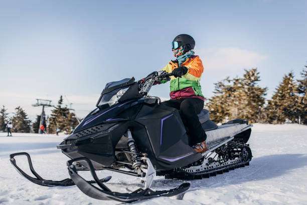 istock Woman sitting on snowmobile 1428318347