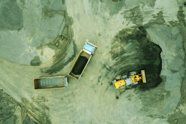 istock Sand loaders are shoveling rocks into dump trucks. 1428321514