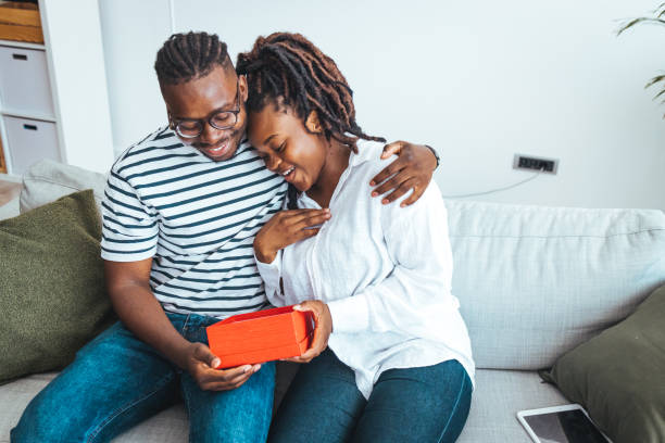 istock Happy couple with gift box hugging at home. 1428327225