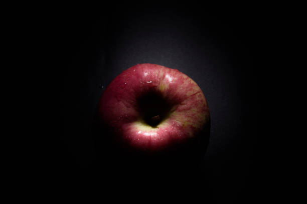 istock top view fresh red apple On a black background with water droplets, lights are falling with space for text. 1428332392