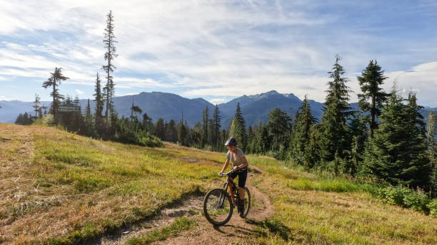 istock Young woman mountain biking along narrow pathway 1428333456