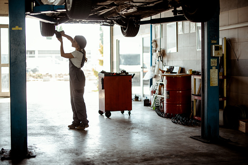 Female Mechanic Working on a Vehicle in a Car Service