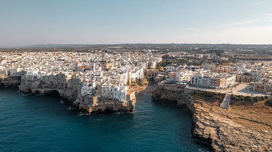 An aerial view of coastal Polignano a Mare cityscape with white buildings in Italy