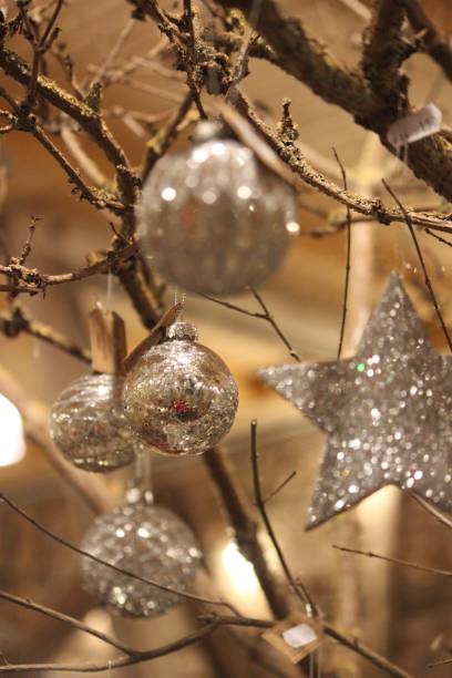 istock Vertical closeup of silver Christmas balls on branches with lights 1428343889