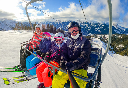Family On Ski Holiday In Mountains Smiling To Camera.