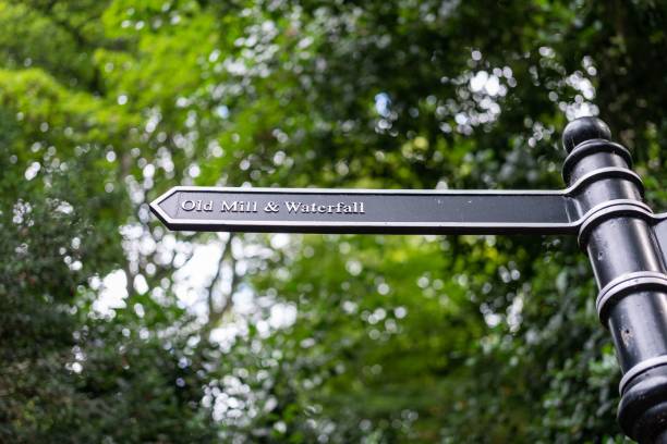 A signposts directs visitors to the old mill and waterfall in Jesmond Dene, Newcastle upon Tyne, UK A signposts directs visitors to the old mill and waterfall in Jesmond Dene, Newcastle upon Tyne, UK. jesmond stock pictures, royalty-free photos & images