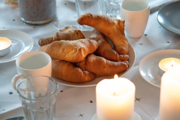 istock Table with a white tablecloth, plate of croissants, and glasses 1428351011