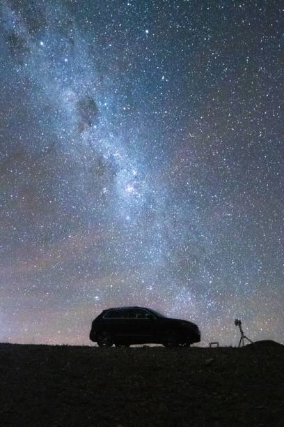istock Scenic vertical view of a car under a mesmerizing starry sky 1428355081