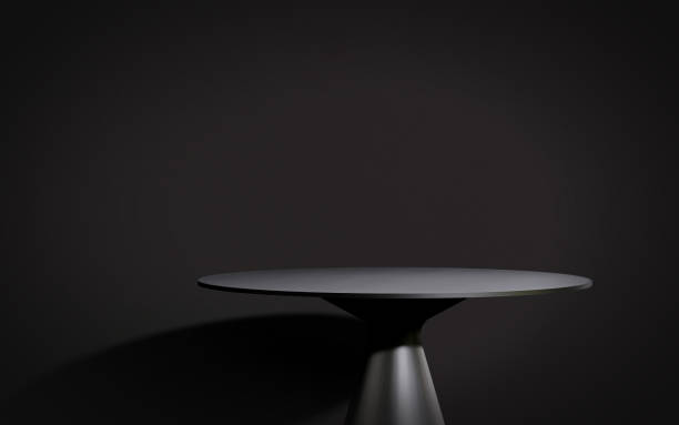 Modern and minimal steel black smooth round podium side table in sunlight on black wall background for luxury beauty and fashion product display