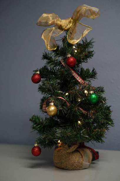 istock Small Christmas tree with Christmas balls on the table 1428359336