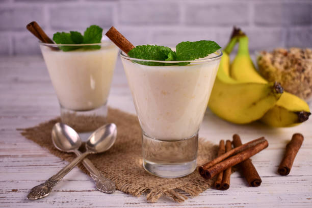 istock Two banana yogurts with cinnamon on a white wooden background. 1428359645