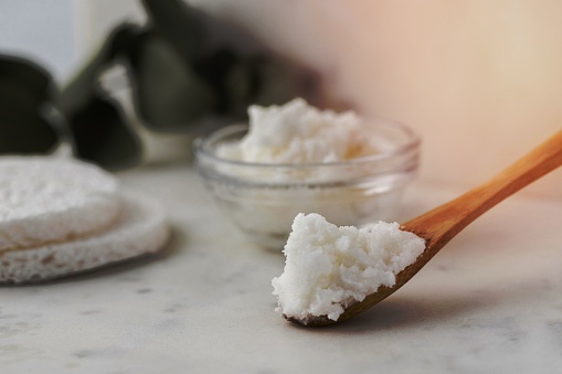 A closeup of a spoonful of Shea butter.